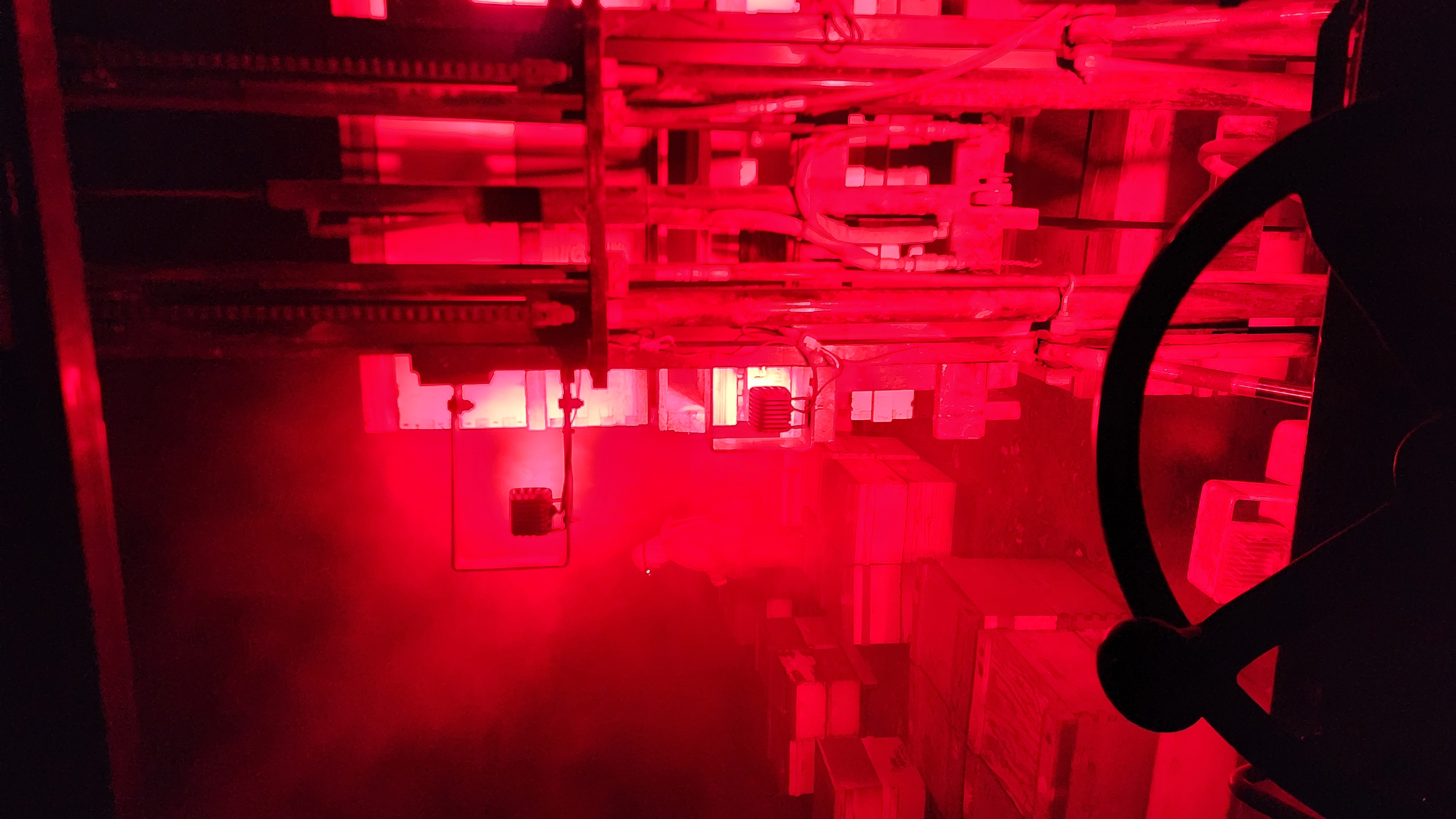 The forklift working through red-lit haze during a night hive delivery